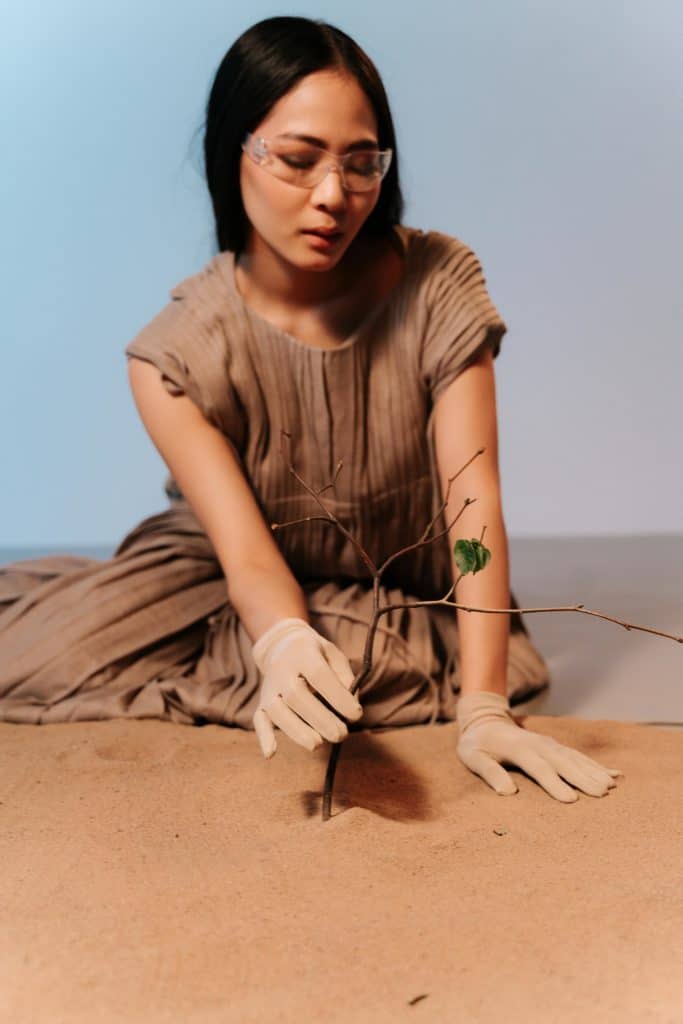 Une femme observe une plante avec des lunettes de scientifique